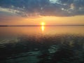 Sunset Background. Selective focus sun sets over horizon on lake. Setting sun is reflected in surface of water. Beautiful golden Royalty Free Stock Photo