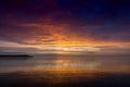 Sunset on the background of the water. Reflected orange and purple light on the clouds