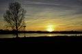 Sunset with bare tree, stork nest and river Royalty Free Stock Photo