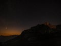 Sunset barely illuminates rocky mountaintop under the starry sky in Julian Alps. Royalty Free Stock Photo