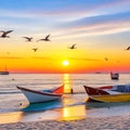 Sunset on the beach with boats in the sea and seagulls flying overhead Royalty Free Stock Photo