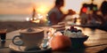 sunset beach cafe ,cup of coffee ,glass of wine,weet cake and flowers on table ,romantic couple relaxing, Royalty Free Stock Photo