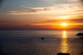 Sunset on the beach with clouds. Calm sea water. Beautiful colors in the sky. Blue and orange shades. Quiet place. Relaxing scene Royalty Free Stock Photo