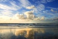 Sunset, beach and clouds on landscape in nature, evening sun and calm ocean with blue sky. Waves, summer skyline and Royalty Free Stock Photo