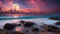 sunset on the beach full moon over the ocean with rocks on the beach Royalty Free Stock Photo