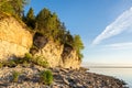 Sunset on the beach. Limestone cliff in the sea under blue sky and white clouds Royalty Free Stock Photo