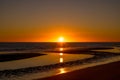 sunset on the beach near the ocean and some sand with water in it Royalty Free Stock Photo