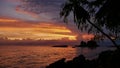 Sunset on the beach with orange colored sky and sunbeam, granite rock formations and docking rowboat at the coast of Praslin. Royalty Free Stock Photo