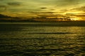 Sunset at the beach by the pier on a cloudy romantic day