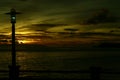 Sunset at the beach by the pier on a cloudy romantic day