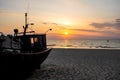 Sunset on the beach on the Polish Baltic Sea. Fishing boat in the evening