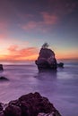 Sunset on the beach. Rock in the ocean. Seascape background. Foreground with stones. Colorful sky. Silky water. Slow shutter speed Royalty Free Stock Photo