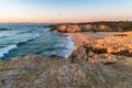 Sunset in beach with rocks in Porto Covo in Alentejo, Portugal Royalty Free Stock Photo