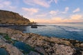 Sunset on the beach, rocky cliffs, and beautiful cloudy sky in the background Royalty Free Stock Photo