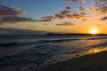 Sunset at the beach with a scenic lighthouse on a cliff. Royalty Free Stock Photo