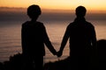 Sunset, beach and silhouette of couple holding hands for date by the sea with dark shadow, love and care. Horizon, ocean Royalty Free Stock Photo