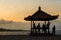 Sunset on the beach, silhouette hut and a few people