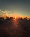 a sunset at the beach with two benches and a street light Royalty Free Stock Photo