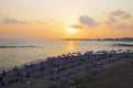 Sunset on the beach with umbrellas and sunbeds. SODAP Beach, Paphos, Cyprus Royalty Free Stock Photo