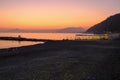 sunset on the beach with yellow sunbeds over the sea and horizon and hills with hotels. Sestri Levante, Liguria, Italy Royalty Free Stock Photo