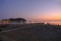 sunset on the beach with yellow sunbeds over the sea and horizon and hills with hotels. Sestri Levante, Liguria, Italy Royalty Free Stock Photo