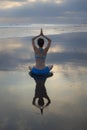 Sunset beach yoga practice in Bali. Lotus pose. Padmasana. Hands in namaste mudra. Meditation and concentration. Zen life. Royalty Free Stock Photo