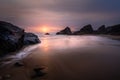 Sunset at the beautiful Bedruthan Steps in North Cornwall, with Silhouetted Sea Stacks, and Surf over Beach