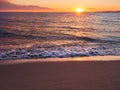 Sunset on a beautiful empty sandy beach - foamy waves