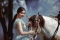 At sunset, a beautiful girl and her horse go through the woods. Horses are adored by girls Royalty Free Stock Photo