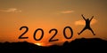 Sunset with mountain silhouette and man jump on new year 2019 cross to 2020 Royalty Free Stock Photo