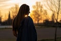 sunset with a young woman with her jacket slung over her shoulder