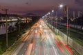 Beggining the night in metropolis, bright lights and vehicles in transit. Sao Paulo city highway beside the river. Skyline Royalty Free Stock Photo