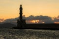 Sunset behind an ancient stone lighthouse Venetian Port, Chania, Crete Royalty Free Stock Photo