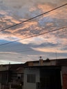 Sunset behind clouds and house building and blue sky Royalty Free Stock Photo