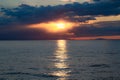 The sunset behind the clouds with the sea line with sun reflection on the water Royalty Free Stock Photo