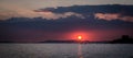 Sunset behind dark cloud above island