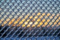 Sunset Behind an Ice Covered Chain Link Fence