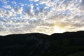 The Sunset behind mountain with beautiful sunbeam through the cloud Royalty Free Stock Photo