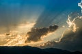 Sunset behind mountain with beautiful sunbeam through the cloud Royalty Free Stock Photo