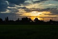 The sunset behind paddy fields and trees. Royalty Free Stock Photo