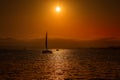 Sunset behind the silhouette of a sailboat catamaran in San Diego