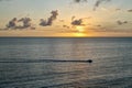 Sunset Behind a Small boat on a Vast Sea With Glowing Golden Sky