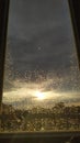Sunset behind windowglass with raindrops. Royalty Free Stock Photo