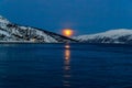 Sunset beyond Arctic Circle. Sun against snow covered mountains.