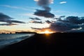 Sunset on black beach near Vik with Dyrholaey rock at background