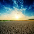 Sunset in blue sky over drought earth Royalty Free Stock Photo