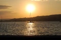 Sunset at the lakeside with a sailingboat on its way home Royalty Free Stock Photo