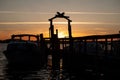 Sunset with boats docked and securely moored to a pier