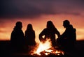 sunset bonfire fun watching sitting silhouettes people having silhouette balefire enjoyment gathering friends family relaxation Royalty Free Stock Photo