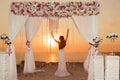 Sunset. bride silhouette. Wedding ceremony arch with flower arrangement, white curtain and crystals chandelier on cliff above sea Royalty Free Stock Photo